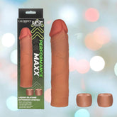 The image features the CalExotics Performance Maxx Liquid Silicone Extension System - Brown, its "Performance Maxx" packaging, and two cap-like attachments, all displayed against a colorful, blurred background.